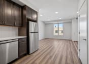 Thumbnail 17 of 45 - an empty kitchen and living room with a refrigerator and cabinets