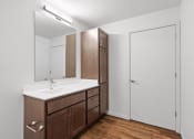 Thumbnail 27 of 36 - A bathroom with a sink, mirror, and wooden cabinets.