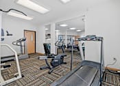 Thumbnail 23 of 27 - a gym with cardio equipment and weights on the floor