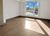 Thumbnail 6 of 22 - an empty living room with wood flooring and a window