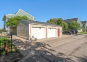 Thumbnail 20 of 27 - a garage with two white doors and a driveway in front of a house