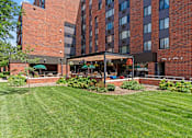 Thumbnail 4 of 55 - a large brick building with a lawn and garden in front of it