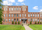 Thumbnail 24 of 31 - a large brick building with a sidewalk in front of it