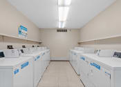 Thumbnail 26 of 43 - a washer and dryer hall with white washers and dryers on the