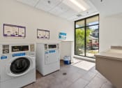 Thumbnail 47 of 52 - a laundry room with washing machines and a sink and a window