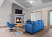 Thumbnail 2 of 25 - a living room with two blue couches and a fireplace