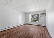 Thumbnail 14 of 23 - an empty living room with wood floors and a window