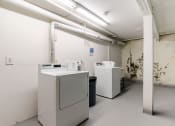 Thumbnail 26 of 27 - three washing machines in a white room with a dirty wall