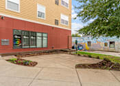 Thumbnail 18 of 35 - a sidewalk in front of a building with a mural on the side