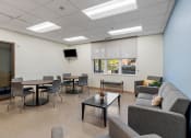 Thumbnail 21 of 52 - a common room with couches tables and chairs and a television