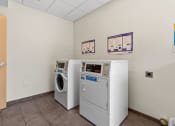 Thumbnail 46 of 52 - a laundry room with two machines and two washes in it