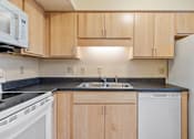 Thumbnail 20 of 23 - A kitchen with wooden cabinets and white appliances.