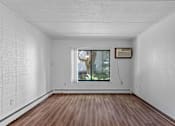 Thumbnail 13 of 23 - an empty room with a window and wooden floors