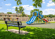 Thumbnail 31 of 41 - a playground with a blue slide in a park