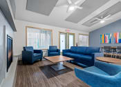 Thumbnail 1 of 25 - a living room with blue couches and chairs and a table