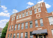 Thumbnail 22 of 31 - a red brick building with a black and white awning