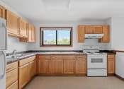 Thumbnail 23 of 43 - a kitchen with wooden cabinets and white appliances and a window