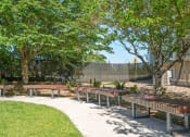Thumbnail 12 of 27 - a sidewalk with benches and trees in a park