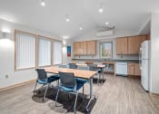 Thumbnail 19 of 25 - a conference room with a kitchen and a table with chairs