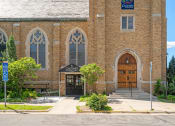 Thumbnail 37 of 45 - the front of a brick church with two large doors and a sign