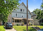 Thumbnail 38 of 67 - a blue house with a car parked in front of it