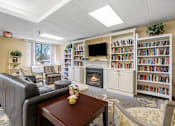 Thumbnail 3 of 25 - a living room with a fireplace and book shelves