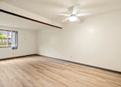 Thumbnail 18 of 23 - Empty room with a ceiling fan and wooden floor.