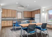 Thumbnail 6 of 25 - a dining room with a table and chairs and a kitchen