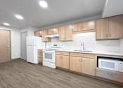 Thumbnail 11 of 22 - an empty kitchen with wooden cabinets and white appliances