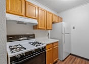 Thumbnail 6 of 23 - a kitchen with white appliances and wooden cabinets and a refrigerator