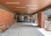 Thumbnail 9 of 55 - the entrance to the building has a long walkway with benches and a brick wall