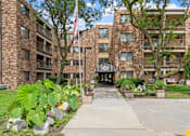 Thumbnail 17 of 25 - exterior view of an apartment building with a sidewalk and an flag