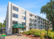 Thumbnail 1 of 23 - a large building with a green sign in front of it