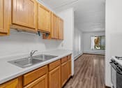 Thumbnail 7 of 23 - a kitchen with a sink and wooden cabinets