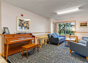 Thumbnail 12 of 25 - a living room with furniture and a piano