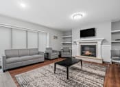Thumbnail 18 of 40 - a living room with a fireplace and couches