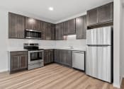 Thumbnail 10 of 45 - a kitchen with wooden cabinets and stainless steel appliances