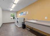 Thumbnail 16 of 52 - a laundry room with a sink and a washing machine in it
