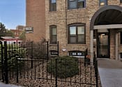 Thumbnail 66 of 67 - a brick building with a gate and a sidewalk in front of it