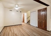 Thumbnail 16 of 23 - A room with a wooden floor and a ceiling fan.