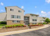 Thumbnail 37 of 57 - an apartment building with a stone retaining wall and flower beds