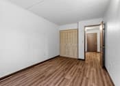 Thumbnail 12 of 23 - an empty living room with white walls and wooden floors and a closet