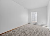 Thumbnail 10 of 27 - a bedroom with white walls and carpet and a window