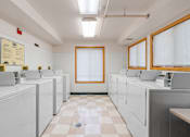 Thumbnail 23 of 25 - a laundry room filled with white washers and dryers