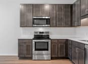 Thumbnail 2 of 45 - a kitchen with stainless steel appliances and dark wood cabinets