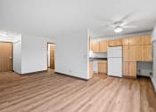 Thumbnail 10 of 25 - an empty living room and kitchen with wood floors and white walls