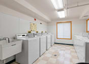 Thumbnail 22 of 25 - a row of washers and dryers in a laundry room