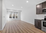 Thumbnail 5 of 45 - an empty kitchen and living room with wood flooring and a window