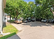 Thumbnail 32 of 67 - a parking lot with cars parked in front of a house