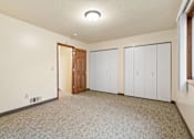 Thumbnail 14 of 23 - A room with a carpeted floor, a ceiling light, and a door leading to another room.